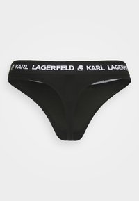 Svart stringtrosor i mjukt tyg, med en kontrasterande vit logoband som har "KARL LAGERFELD" i tryck och en tecknad detalj.