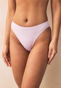 Gaiši rozā augsto jostasvietu bikini apakšdaļa ar gludu tekstūru un mērenu segumu, veidota ar tīrām līnijām un bez rakstiem.