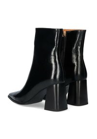 Stivaletti alla caviglia in pelle nera con finitura lucida, punta appuntita e tacco spesso. Dotati di una cerniera laterale per un facile utilizzo.