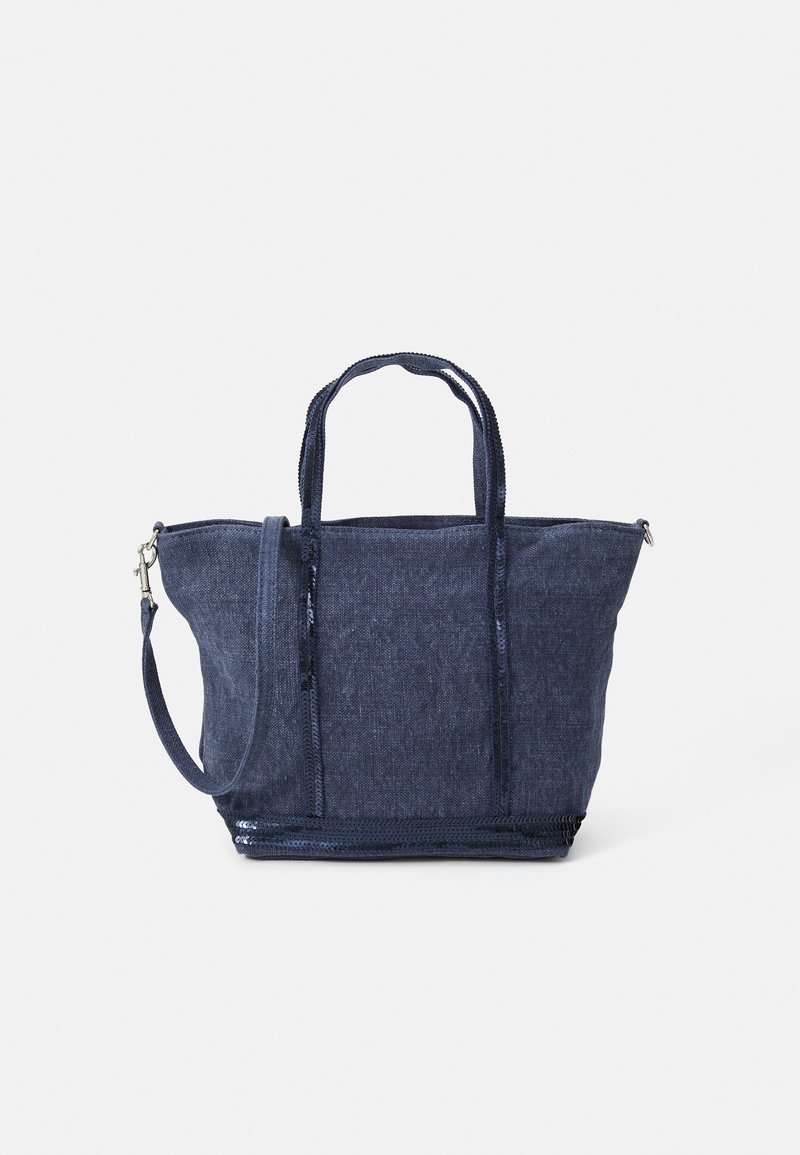Sac en toile en denim bleu marine avec deux poignées, une bandoulière amovible, une fermeture éclair et une finition texturée ; présente un design structuré et spacieux.