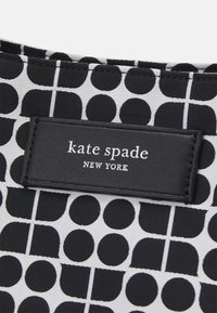 Tessuto a motivo bianco e nero con forme circolari e semicircolari, con un'etichetta in pelle nera impresso con "kate spade NEW YORK."