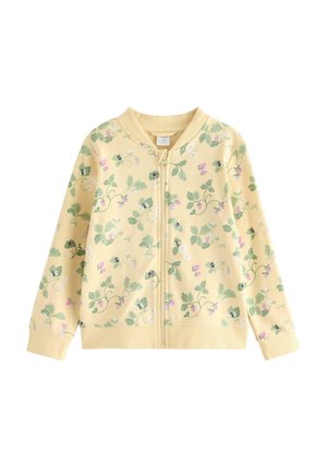 Lys gul lynlåstrøje med grønt blad- og lille pink blomsterprint, med ribstrikket krave, manchetter og kant.