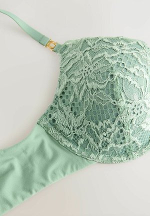 Soutien-gorge en dentelle verte avec une superposition de dentelle à motifs floraux et une bande inférieure lisse. Accentué par un ajustement de sangle en matériel doré.