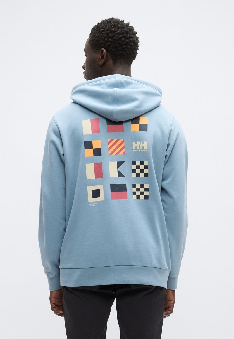 Ανοιχτό μπλε φούτερ με κουκούλα που διαθέτει εκτύπωση με διάφορα γεωμετρικά σχήματα και χρώματα στην πλάτη, με κουκούλα με κορδόνια και ριμπ μανσέτες.