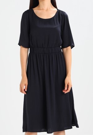 Robe bleu marine au genou en tissu léger avec manches courtes et encolure dégagée, dotée d'une taille élastique pour un ajustement confortable.
