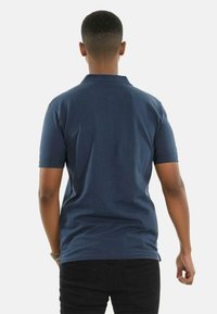 Navy blue polo shirt with short sleeves, a classic collar, and a straight hem. Soft cotton fabric with no visible patterns or accents.