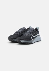 Baskets de sport noires et grises avec un dessus en maille, une semelle texturée et des accents réfléchissants. Comprend des lacets et une languette au talon.