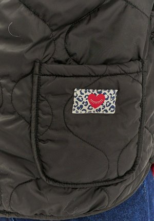 Černá prošívaná bunda s boční kapsou, která je zdobena leopardím potiskem a designem červeného srdce. Texturovaný, izolační materiál.