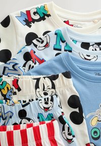 Ensemble de vêtements pour enfants avec des visages de Mickey Mouse, des lettres colorées, des pois noirs et un short rayé rouge et blanc, étalé à plat.