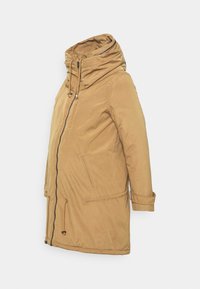 Manteau d'hiver long de couleur camel avec col haut, fermeture éclair à l'avant, cordons de serrage et poches latérales, présenté sur fond blanc.