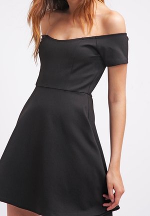 Robe noire épaules dénudées avec manches courtes, corsage ajusté et jupe évasée, confectionnée dans un tissu lisse avec un design sans coutures.