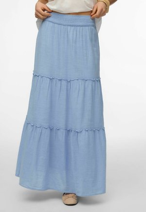 Jasnoniebieska warstwowa długa spódnica maxi z elastycznym pasem, noszona z beżowymi balerinami, pokazana od talii do stóp na białym tle.