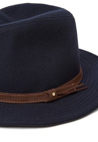 Cappello navy in feltro con una larga tesa, dotato di una fascia in suede marrone e un accento dorato. Texture liscia e silhouette strutturata.