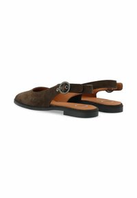 Scarpe slingback in suede marrone con un taglio rotondo, cinturino regolabile con fibbia metallica e suola in gomma piatta. Soletta tan visibile.