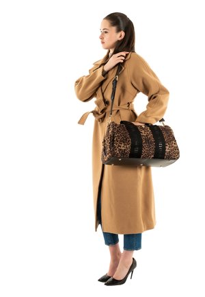 Bruine wollen trenchcoat met een ceintuur, gecombineerd met een tas met luipaardprint en zwarte banden met een zachte textuur. Zwarte hakken maken de look compleet.