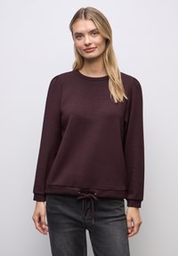 Burgundy pullover-sweatshirt valmistettu pehmeästä kankaasta, jossa on pyöreä kaula-aukko, pitkät hihat ja säädettävä nyöri helmassa.