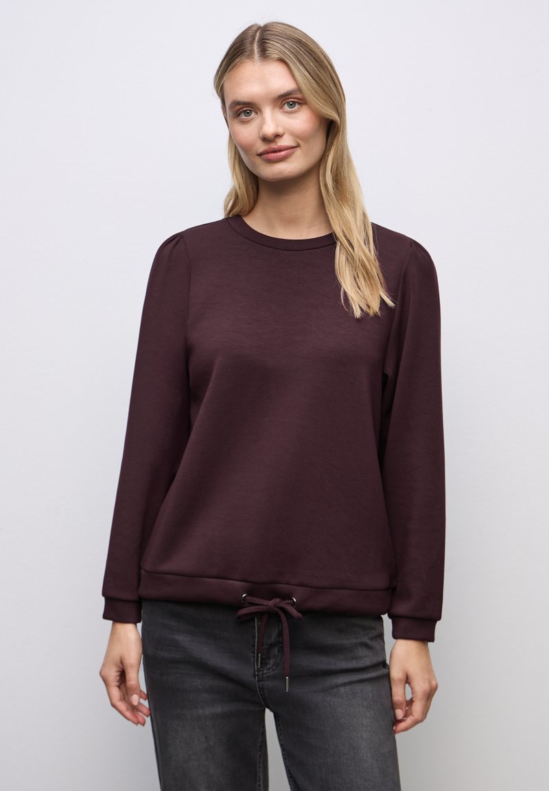 Burgundy pullover-sweatshirt valmistettu pehmeästä kankaasta, jossa on pyöreä kaula-aukko, pitkät hihat ja säädettävä nyöri helmassa.