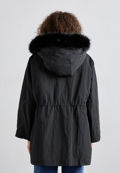 Black parka jacket with a faux fur hood, drawstring waist, and long sleeves. Textured fabric with a relaxed fit, extending past the hips.