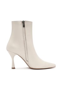Bota de tobillo de cuero blanco con punta afilada, tacón de aguja delgado y cierre de cremallera lateral. Textura suave y diseño elegante.