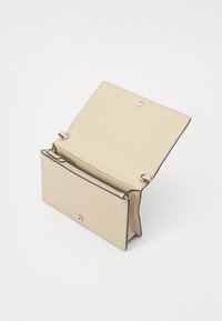 Portafoglio in pelle beige con chiusura a pressione, aperto per rivelare un interno con più scomparti e una sezione con zip. Texture liscia.