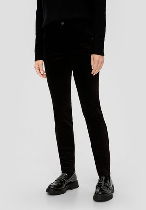 Zwarte corduroy broeken met een slim fit, voorzien van zijzakken, een knoopsluiting en een gladde textuur. Draagt met glanzende zwarte loafers.