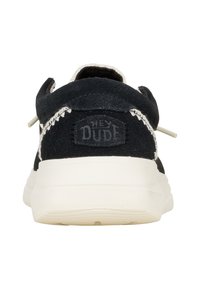 Sneaker in suede nera con suola in gomma bianca. Presenta un retro rotondo, cuciture decorative e un logo "HEY DUDE" sul tallone.