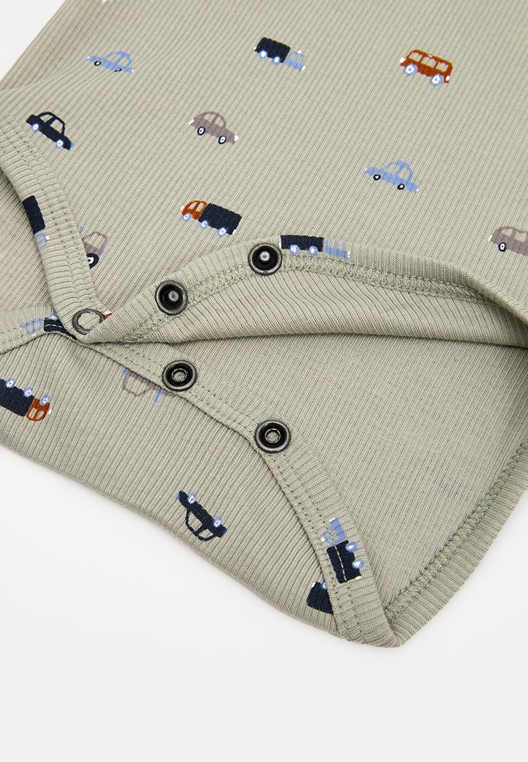 Hellgrünes, geripptes Kleidungsstück mit bunten Auto-Drucken. Verfügt über schwarze Druckknöpfe am unteren Ende zur Verschluss. Glatte Textur, lässiges Design.