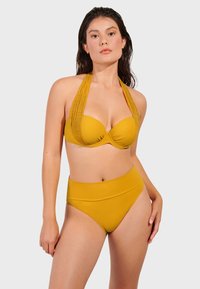 Žuti bikini set s dizajnom halterneck-a i teksturiranim trakama, uz visoki struk. Glatka tkanina i minimalistički stil.