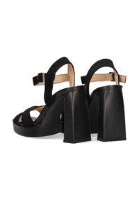 Sandalias de tacón alto negras con parte superior de tipo ante, punta abierta, diseño de tres tiras y tacones cuadrados gruesos. Cierre con hebilla en el tobillo.