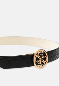 Schwarzer Gürtel mit eingeprägtem Logomuster, goldfarbener runder Schnalle mit ineinandergreifenden Initialen und cremefarbenem Innenfutter.