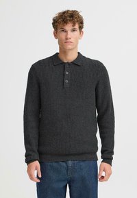 Mørkegrå strikket langermet polo genser med et teksturert mønster og tre-knap placket. Mykt materiale, casual passform, ribbede mansjetter og nederkant.