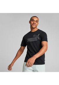 Camiseta de algodón negra con un gran logo blanco de "PUMA" y un gráfico de gato en el pecho, mangas cortas y un diseño de cuello redondo.