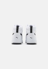 Białe wysokie sneakersy z czarnymi akcentami, charakteryzujące się gładką skórzaną cholewką i teksturowanym kołnierzem. Gumowa podeszwa z detalem logo.