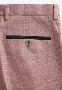 Helle rosa karierte Hosen mit einer Gesäßtasche mit schwarzem Besatz und einem kontrastierenden Knopf. Glattes Gewebe mit einer subtilen Textur.