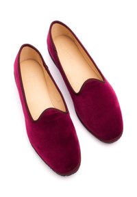 Scarpe slip-on in velluto color bordeaux con punta arrotondata e bordatura marrone a contrasto, caratterizzate da una superficie liscia e design minimale.