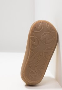 Suola della scarpa in gomma testurizzata di colore marrone chiaro. Le linee curve notevoli e il dettaglio del logo impresso migliorano la presa e il design.