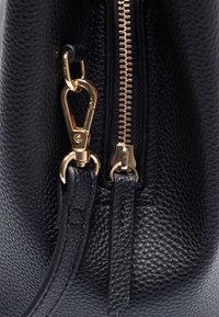 Borsa a tracolla in pelle nera con texture, caratterizzata da una cerniera e accessori in oro. Include un attacco a clip e una tracolla in pelle.