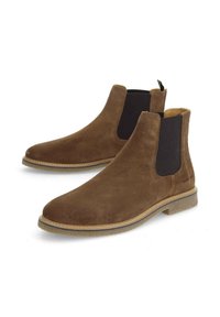 Bottes Chelsea en cuir suédé marron avec des panneaux élastiques sur les côtés et une languette de tirage. Présente une semelle texturée et des coutures soignées le long des bords.
