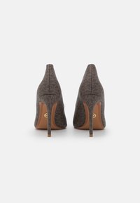 Escarpins bruns à talons hauts avec un tissu à motifs, bout pointu et talons stilettos fins. Présente un accent de logo sur la semelle intérieure.