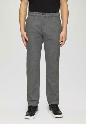 Graue Hose aus strukturiertem Stoff, mit Knopfverschluss, Gürtelschlaufen und geradem Bein, kombiniert mit schwarzen Sneakers.