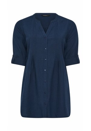 Navyblå, lang tunikabluse med pintuck-detaljer, syv knapper foran, 3/4-lange ærmer med knapstropper til at rulle op og en let V-udskæring på kraven.