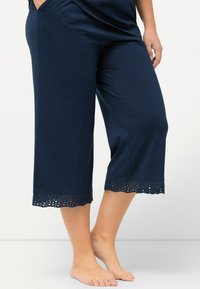 Pantalons culotte navy en tissu doux avec un ourlet en forme de coquille et des découpes œillets. Longueur mi-mollet avec une coupe décontractée.