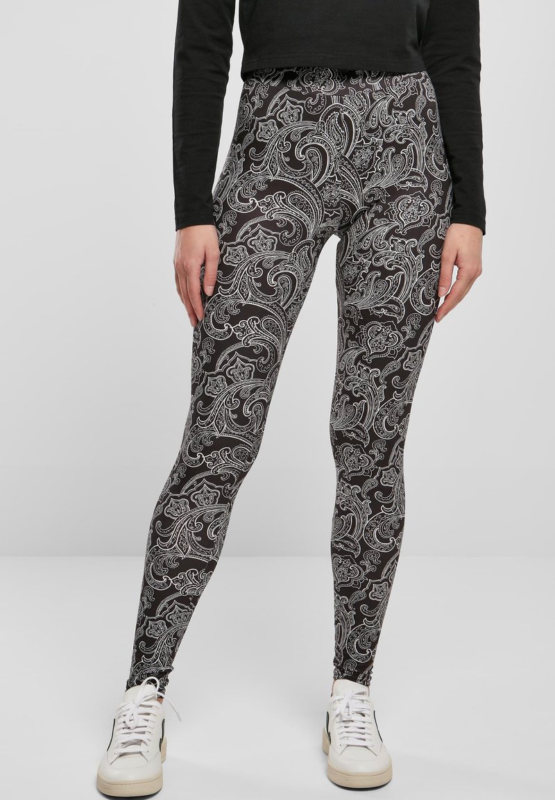 Leggingse izrađene od rastezljivog materijala, s crnom pozadinom i složenim bijelim paisley uzorkom. Visoki struk s uskim krojem.