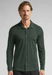 Mörkgrön långärmad skjorta med knappar i mjukt tyg, med klassisk krage, knappar framtill och en avslappnad passform.