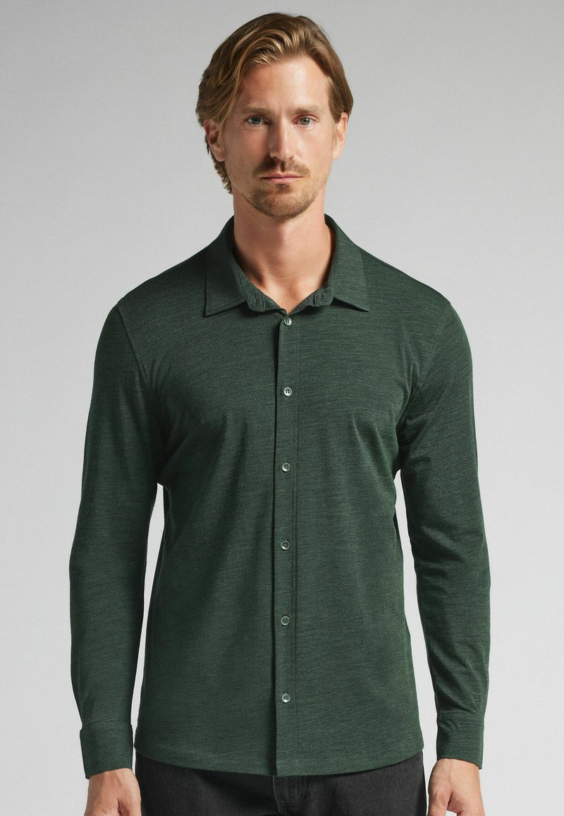 Mörkgrön långärmad skjorta med knappar i mjukt tyg, med klassisk krage, knappar framtill och en avslappnad passform.