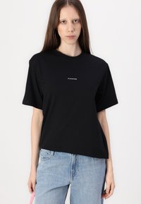 Black short-sleeved T-shirt made of cotton, featuring a crew neck and the word "FEMME" printed in white on the front.