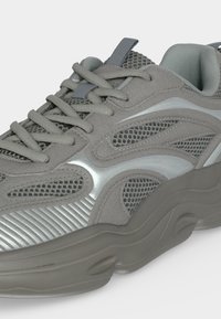 Baskets grises avec parties en mesh et synthétiques, col rembourré et semelle épaisse et sculptée, vues d'un angle avant-latéral.
