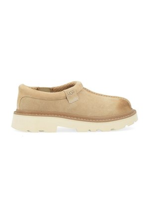 Scarpa slip-on in suede beige con soletta testurizzata, colletto imbottito e suola spessa in gomma bianca, con discreta marchiatura sul lato.