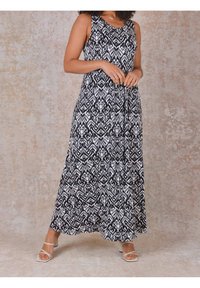 Maxi šaty bez rukávů s černobílým vzorovaným materiálem, uvolněným střihem a splývavou siluetou.