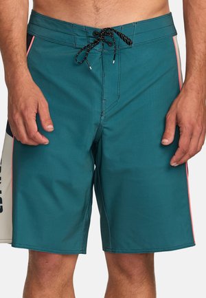Türkisfarbene Boardshorts aus schnelltrocknendem Material, mit einem schwarzen Kordelzug, seitlichen Streifenakzenten in Pink und einem Logo auf der linken Seite.